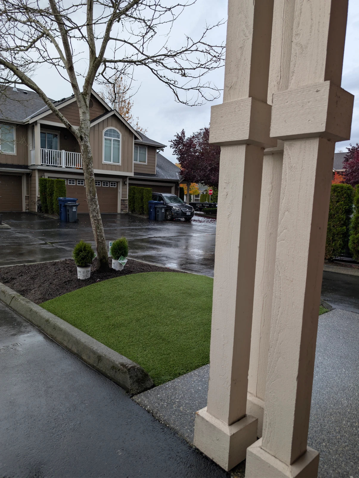 K9Grass Elite pet turf patch installed in front yard landscaping bed with small shrubs, townhome complex, Marysville WA