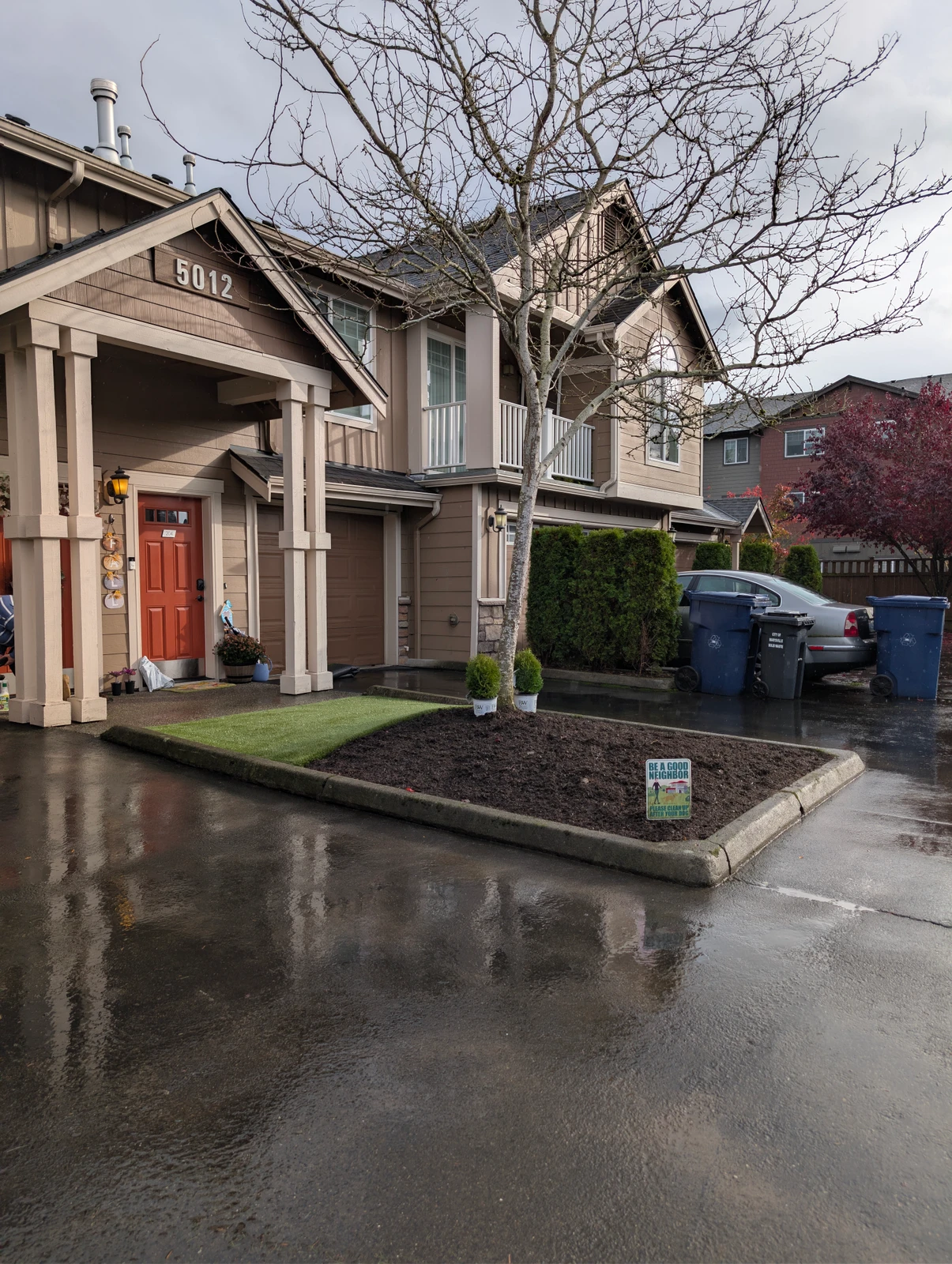 K9Grass Elite pet turf patch installed in front yard median with fresh mulch and boxwood shrubs at Marysville WA home.